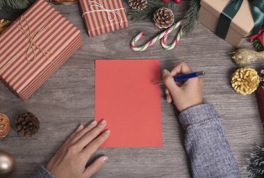 El yazısı Mutlu Noeller ve yeni yılınız kutlu olsun tebriklerimi sunarken ahşap masada Noel süslemeleri vardı..