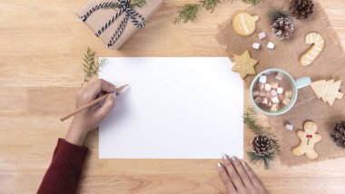 Liste yapmak için el yazısı maketi, marşmelovlu sıcak çikolata, ahşap arka planda kurabiye. Kış Noel 'i ve Mutlu Yıllar konsepti.