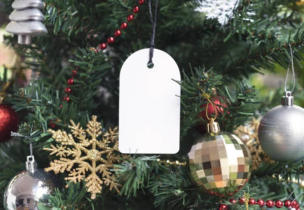 Ajándék címke készült újrahasznosított kártya karácsonyfa háttér. promóciós értékesítés karácsonyra és boldog új évet. — Stock Fotó