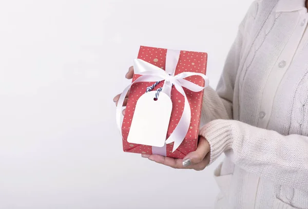 Kobiety trzymając czerwony prezent pudełko i papierową etykietę izolowane na białym tle na Boże Narodzenie i koncepcję nowego roku. — Zdjęcie stockowe
