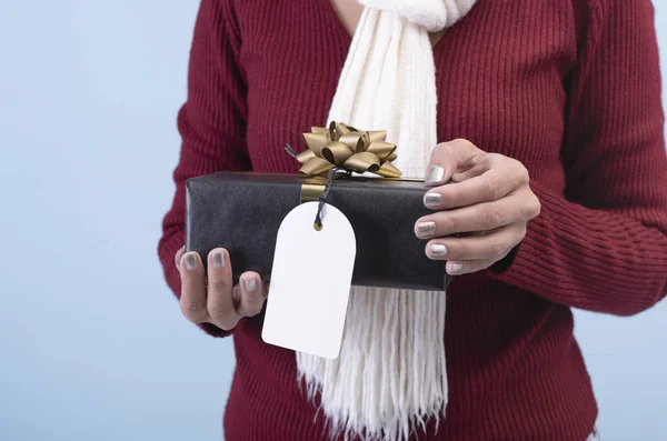 여성들은 크리스마스와 새해 개념을 위해 검정 색 선물 상자와 흰색 배경에 분리 된 종이 태그를 손에 쥐고 있다.. — 스톡 사진