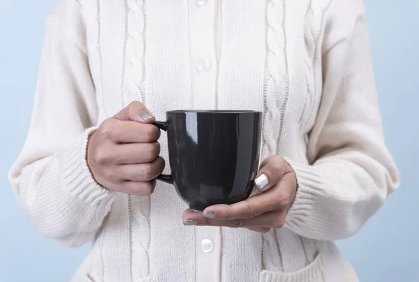 Жіноча рука тримає чорну керамічну чашку кави. макет для креативної реклами текстового повідомлення або рекламного контенту . — стокове фото