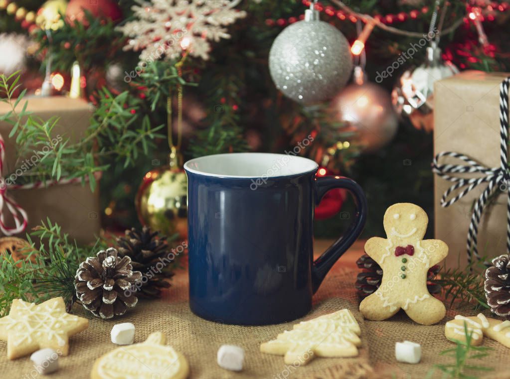 Blue ceramic coffee cup and christmas decoration on woon table background. mockup for creative advertising text message or promotional content.