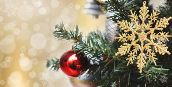 抽象的な光の上のクリスマスツリー上の雪のフレーク黄金のボケの背景. — ストック写真