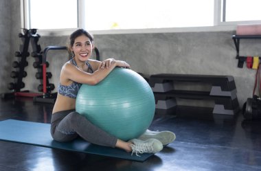 Genç Asyalı gülümseyen sporcu yoga spor salonunda spor salonunda spor yapıyor..