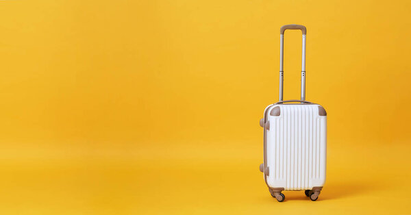 White luggage bag isolated on yellow banner background with copy space for advertisement