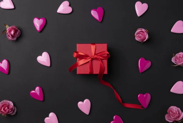 Fondo de San Valentín con corazones rojos y regalo sobre fondo negro . — Foto de Stock