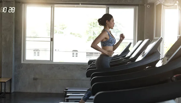 Las mujeres asiáticas corredor de ejercicios en el gimnasio de fitness. estilo de vida saludable y concepto de entrenamiento. — Foto de Stock