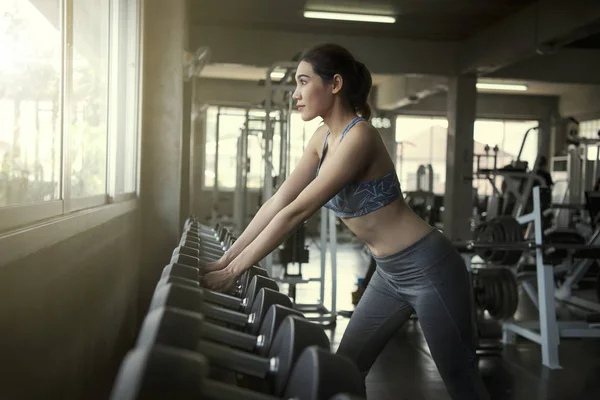 Jonge Aziatische vrouw tillen dumbbells in Gym fitness. gezonde lifestyle en training motivatie concept. — Stockfoto