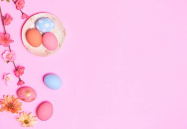 Yaratıcı Paskalya tatil düzeni yumurtaları pembe arka planda çiçekle boyanmış el yapımı boyalar. Mevsimlik düz konsept..