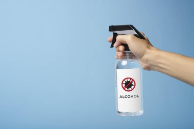 Adam antivirüs bakterisini korumak için sprey alkol kullanıyor. Corona virüsüne karşı önleyici önlemler.