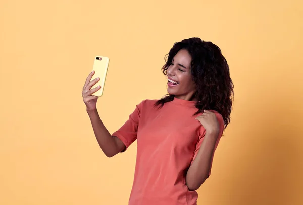 Портрет Щасливої Молодої Африканки Селфі Святкування Мобільним Телефоном Ізольовано Жовтому — стокове фото