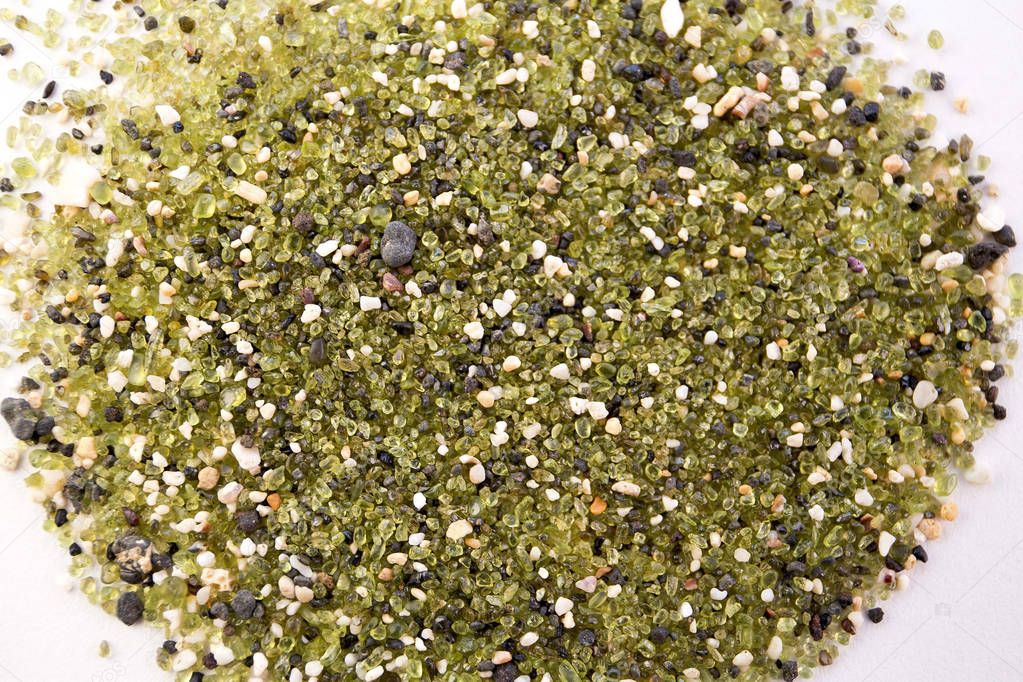 The greenest Papakolea Beach sand closeup on white