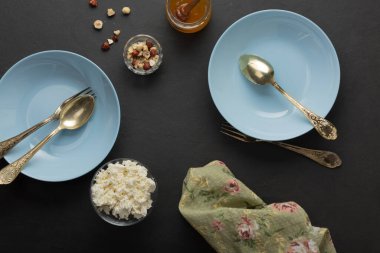 Koyu betonda mavi kahvaltı tabakları. Fındık, bal, meyve. Sağlıklı Yemek