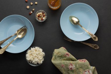 Koyu betonda mavi kahvaltı tabakları. Fındık, bal, meyve. Sağlıklı Yemek