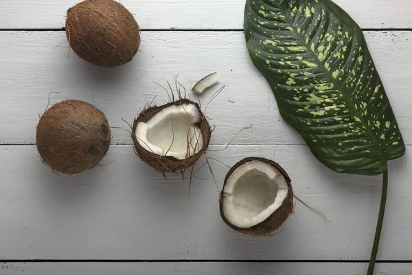 Hackad Kokosnöt Med Gröna Blad Ett Vitt Träbord — Stockfoto