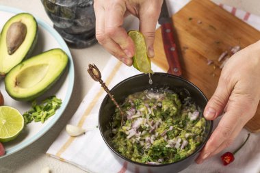 Meksika soslu guacamole hazırlama işlemi. Kadın limon suyundan sıkmış..