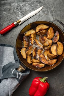 Kırsal yiyecekler. Koyu beton bir masada tavada patates kızartması. Kırsal biçim.
