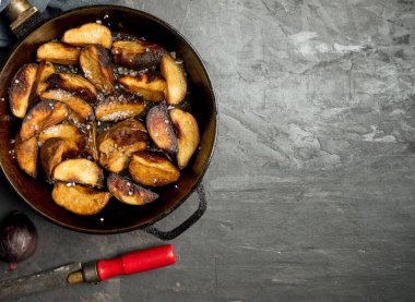 Kırsal yiyecekler. Koyu beton bir masada tavada patates kızartması. Kırsal biçim.