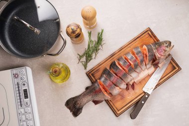 Somon pişiriyorum. Mutfak tahtasında dilimlenmiş taze biftek somonu.