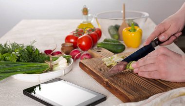 Genç adam sağlıklı sebze salatası hazırlıyor. Aşçının elleri yakın çekim, sağlıklı beslenme, üst görüş.