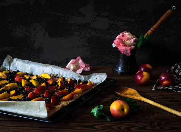 Baking tray with peaches and black currant — Stock Photo, Image