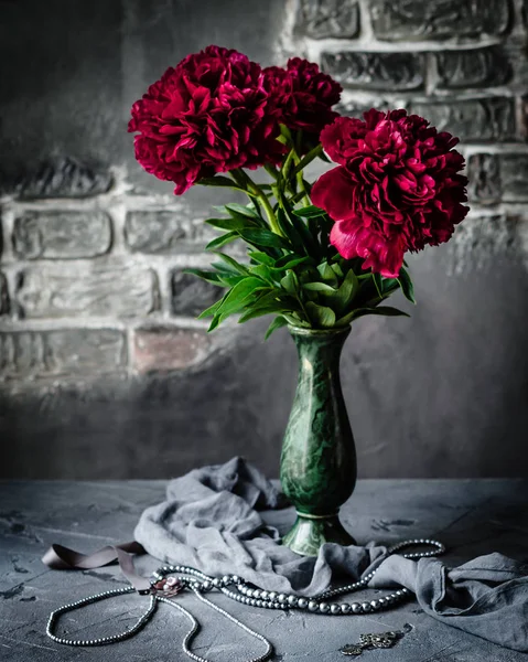 Kolye ile yeşil vazoda kırmızı peonies