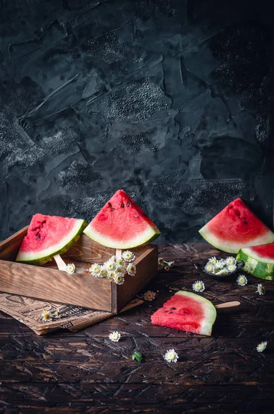 Watermelon slices on wooden sticks