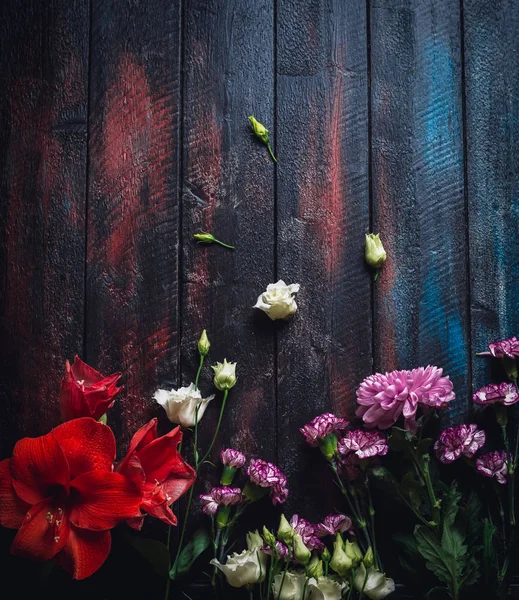 Assorted flowers on colored wooden table