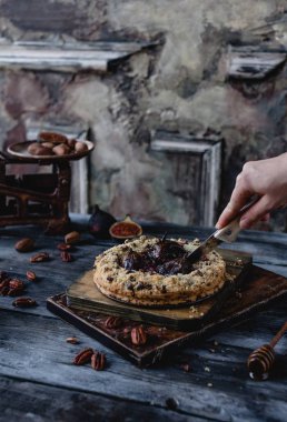 Kadın kesme tatlı incir ve cevizli tart rustik ahşap zemin üzerine 