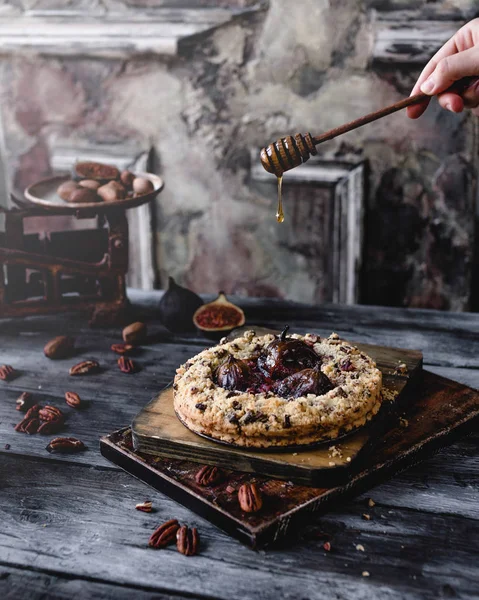 Bal tatlı incir ve cevizli tart rustik ahşap zemin üzerine üzerine dökülen kadın 