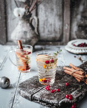 Böğürtlen ve elmalı bitki çayı ahşap tahtada, ahşap zemin üzerinde tarçın, klasik efekt için tonlanmış.