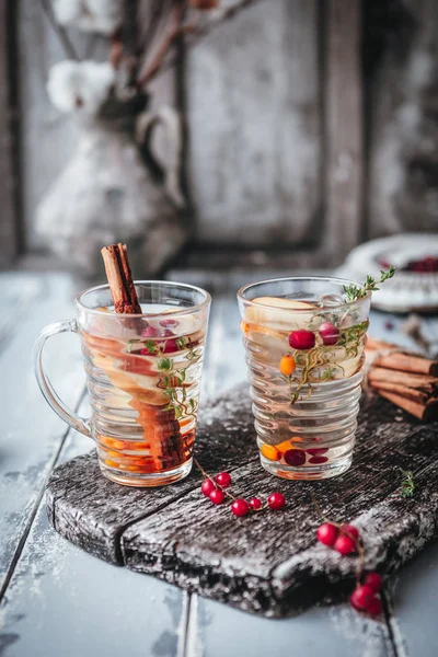 Böğürtlen ve elmalı bitki çayı ahşap tahtada, ahşap zemin üzerinde tarçın, klasik efekt için tonlanmış.