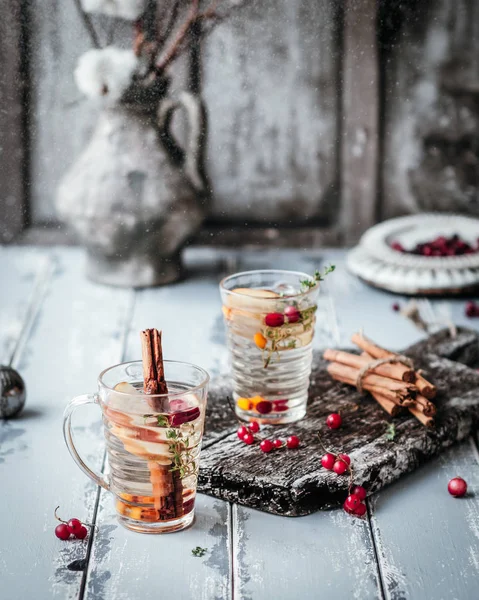 Böğürtlen ve elmalı bitki çayı ahşap tahtada, ahşap zemin üzerinde tarçın, klasik efekt için tonlanmış.