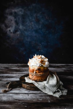 Ev yapımı Paskalya turtası, ahşap kesim tahtasında kahverengi ahşap masada kumaş peçeteyle yakın plan.