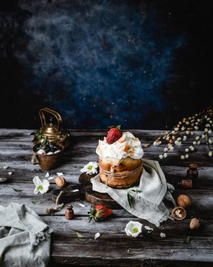 Ev yapımı Paskalya turtası. Taze bahar çiçekleri ve kırsal ahşap arka planda söğütler.