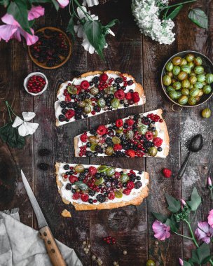 Kremalı peynirli pasta ve kahverengi ahşap masada şekerli böğürtlen çeşitleri, üst manzara, mevsimlik tatlı konsepti. 