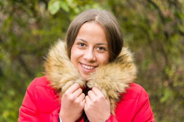 Mujer joven sola en un bosque con abrigo rojo —  Fotos de Stock