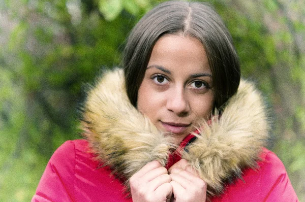 Mujer joven sola en un bosque con abrigo rojo —  Fotos de Stock