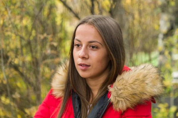 Mujer joven sola en un bosque con abrigo rojo —  Fotos de Stock