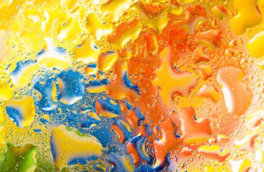 Yeşil mavi turuncu renkli cam üzerinde su damlaları