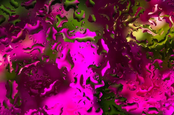 Вода падає на скло з рожево-зеленим фоном — стокове фото