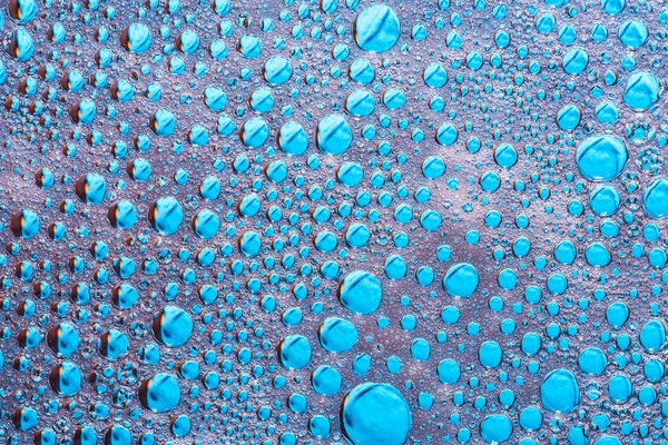 Gouttes d'eau sur verre avec la mousse du lave-vaisselle sur fond bleu — Photo