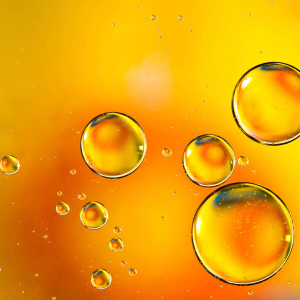 Oil drops in water, bubbles on orange abstract background