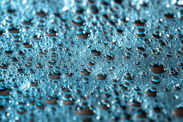 Glanzende druppels water op een blauwe achtergrond, abstract regenachtig behang — Stockfoto