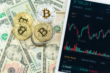 Kağıt dolar banknotları üzerine yığılmış Bitcoin yığınları beyaz modern tablet, borsa şamdan şeması, sanal para birimi, dijital kripto, metal kripto paralar.