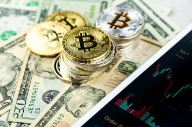 Kağıt dolar banknotları üzerine yığılmış Bitcoin yığınları beyaz modern tablet, borsa şamdan şeması, sanal para birimi, dijital kripto, metal kripto paralar.