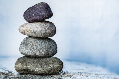 Parlak beyaz arkaplanda dört renkli çakıl taşı yığını