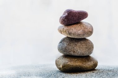 Parlak beyaz arkaplanda dört renkli çakıl taşı yığını