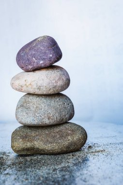 Parlak beyaz arkaplanda dört renkli çakıl taşı yığını